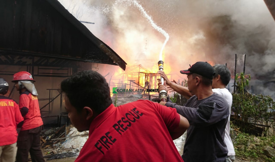 Rumah kayu di Loa Janan Ilir jadi arang, terlihat petugas dari Disdamkar, relawan serta warga saat berupaya memadamkan api Minggu (11/7/2021) hari ini. (Foto: Nancy/korankaltim.com)