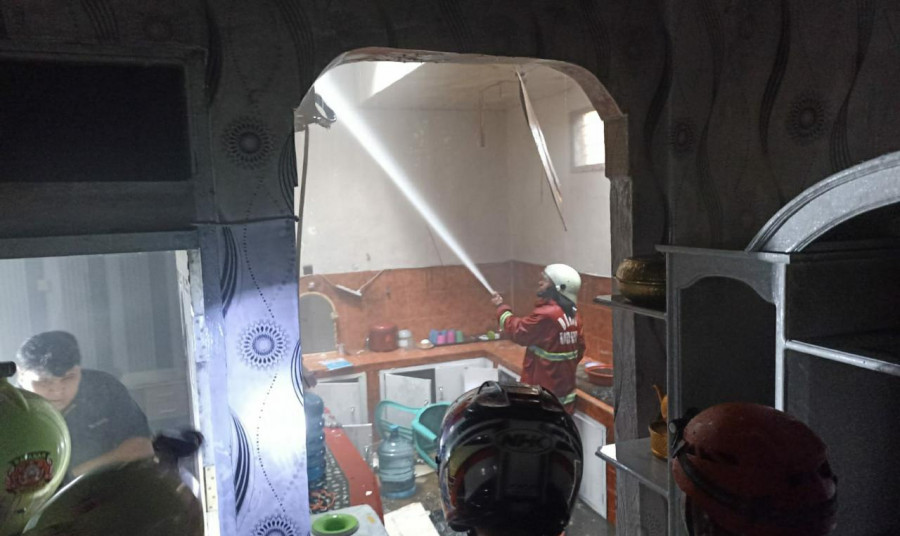Petugas saat menyemprot api yang membakar bagian plafon di dapur Senin (3/1/2022) sore tadi. Foto:Nancy/korankaltim.com)