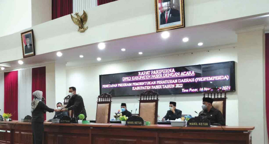 Anggota Bapemperda DPRD Paser Arlina menyerahkan laporan Bapemperda kepada Ketua DPRD, Hendra Wahyudi. ( Foto: Dok.Korankaltim)