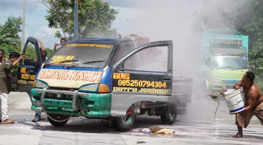 Warga sekitar saat membantu memadamkan mobil yang terbakar di kawasan Bukit Pinang Selasa (2/6/2020) hari ini. (Foto:Nancy/korankaltim.com)