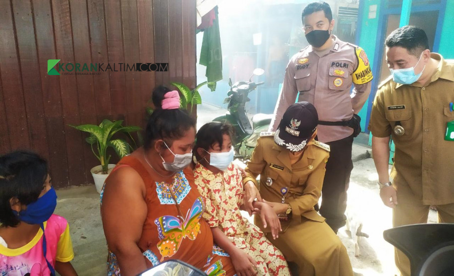 Seorang anak perempuan yang positif DBD dan hanya menjalani perawatan di rumah, saat dikunjungi oleh pihak kecamatan dan lurah Selasa (15/6/2021) hari ini. (Foto: Nancy/korankaltim.com)
