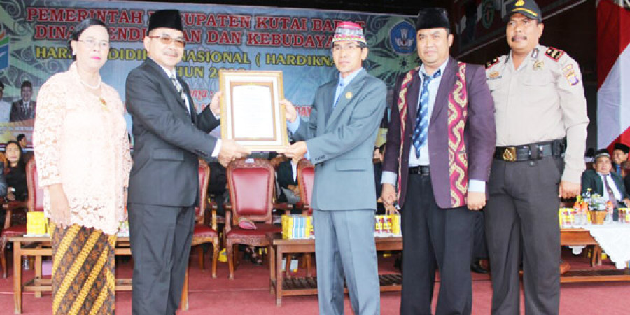 BERI PENGHARGAAN: YAcob Tullur (dua dari kiri) menyerahkan penghargaan kepada guru berprestasi pada Hardiknas tadi pagi.