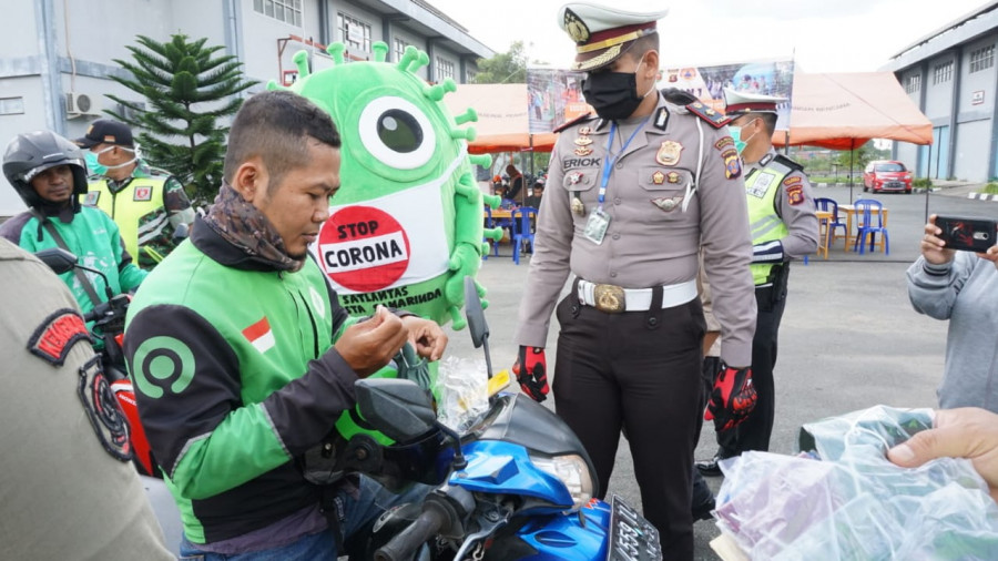 Kasat Lantas Polresta Samarinda (kanan) saat membagikan masker kepada para pengemudi ojol di Posko Lapangan 1 Jalan HM Rifadin Selasa (7/4/2020) hari ini. (Foto: Nancy/korankaltim.com)