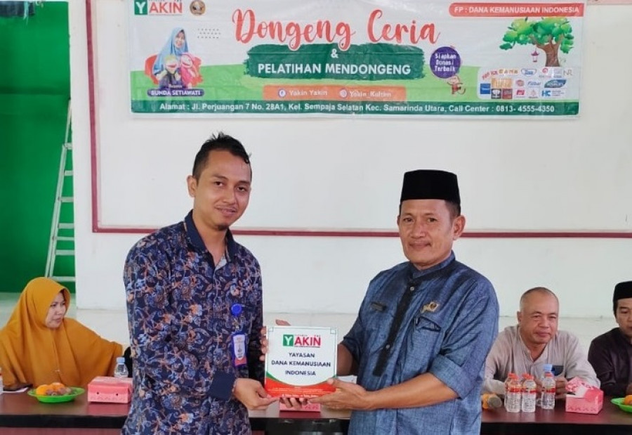 Perwakilan dari Kecamatan Marangkayu saat menerima cinderamata dari panitia kegiatan mendongeng. (Foto: Istimewa)