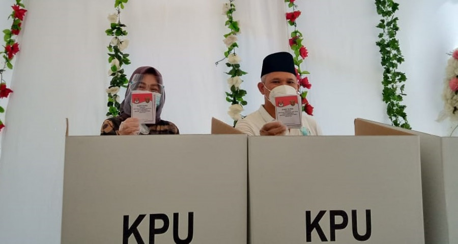 Calon Wali Kota Samarinda Nomor urut 1, Muhammad Barkati dengan Istri menunjukan surat suara yang telah di coblos. (foto: Claudius Vico/Korankaltim.com)