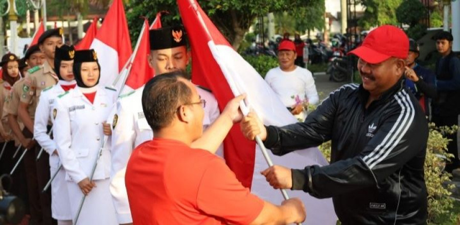 Bupati Edi menyerahkan bendera merah putih kepada FRT se Kecamatan Tenggarong. (Foto: Prokom)