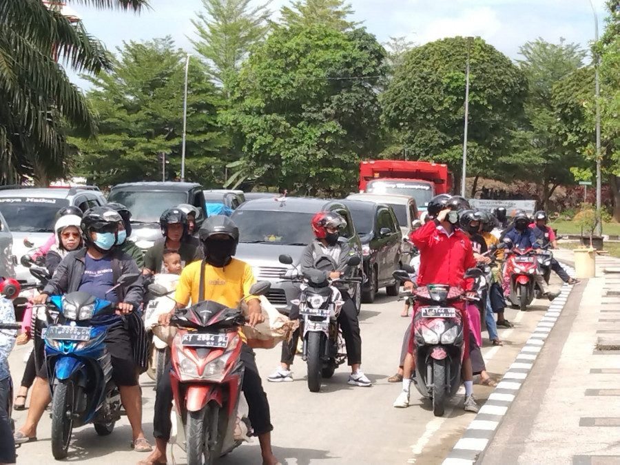 Momen saat salah satu pengendara motor menghentikan kendaraannya dan mengambil sikap hormat saat Sang Saka Merah Putih dikibarkan. (Handayan/korankaltim.com)