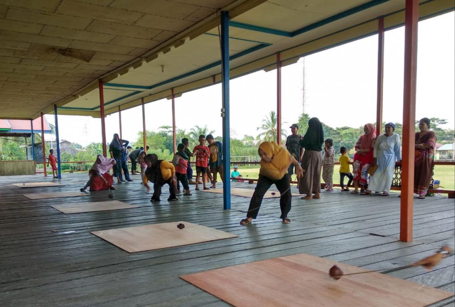 lomba beturai gasing di lapangan Gajah Mada, Muara Muntai Ilir, yang dimainkan oleh wanita dewasa, dalam rangka memperingati hari kesaktian Pancasila 2019. (Foto: Ist)
