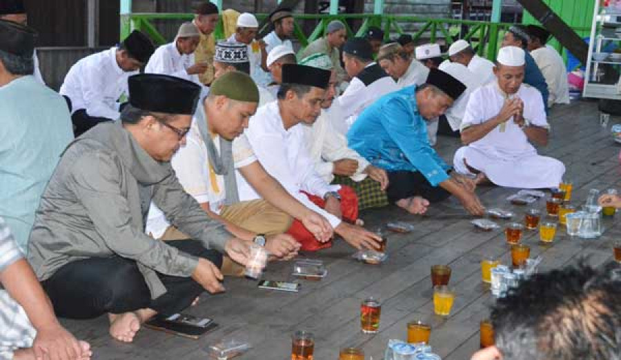 BUKA PUASA : Komisi IV bersama Ketua DPRD buka bersama warga Muara Kaman sekaligus memberikan bantuan satu set tenaga surya . ( istimewa)