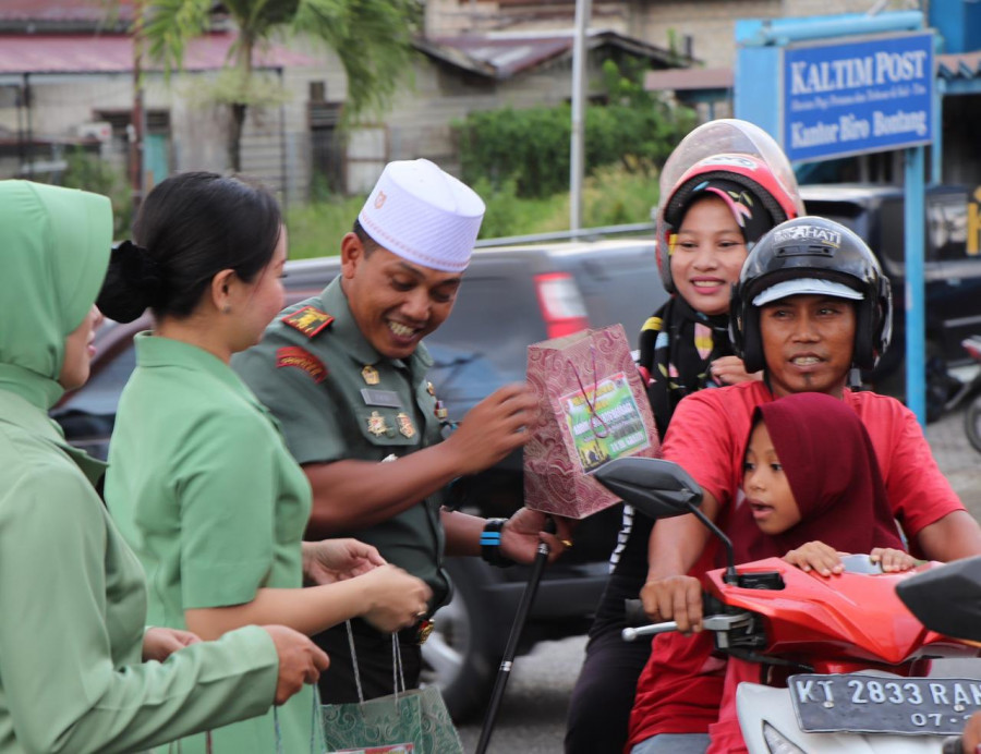 BERBAGI SENYUM. Dandim 0908/Bontang Letkol Arm Eko Pristiono bersama istrinya dan ibu-ibu Persit saat menyerahkan takjil ke pengendara yang lalu lalang di simpang Bontang Baru, Selasa (7/5/2019)