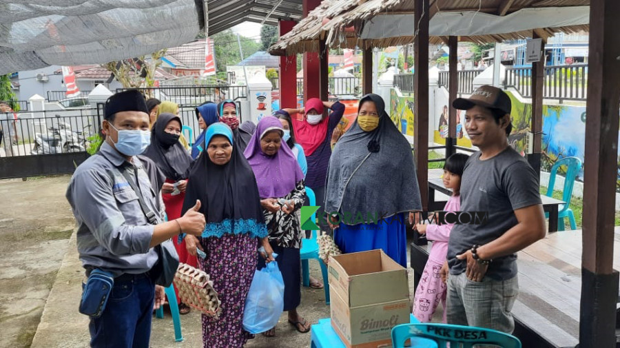 Warga Desa Bhuana Jaya berbondong-bondong menebus paket sembako dengan harga murah yang disediakan PT KMIA (Foto: Permata/korankaltimcom)