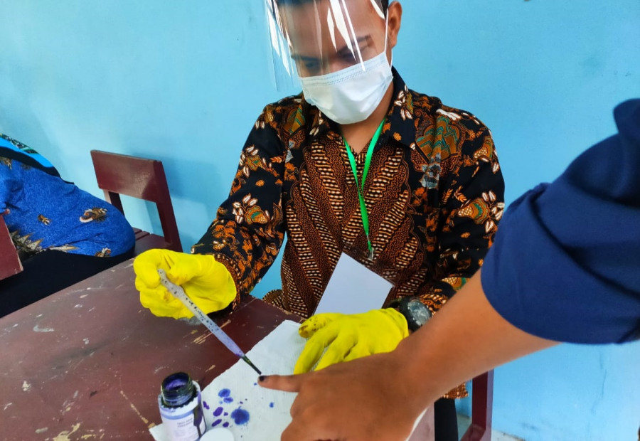 Petugas saat meneteskan tinta ke jari pemilih sebagai tanda usah menyalurkan suara pada Pilkada 2020. (Foto: Reza Fahlevi/korankaltim.com)