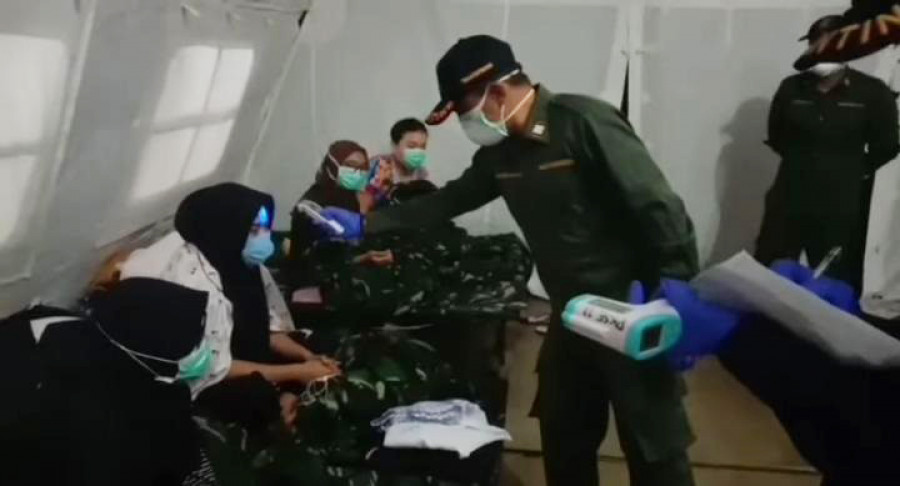 Petugas kesehatan saat melakukan pengecekan kesehatan secara rutin kepada para WNI yang dijemput dari Wuhan pada program observasi di Kabupaten Natuna. ( Foto: Istimewa )