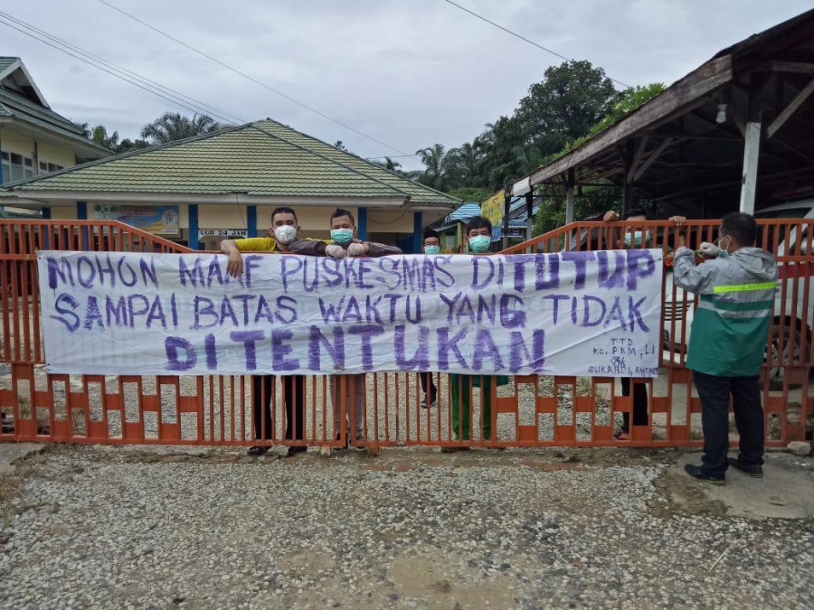 Sebuah spanduk yang menyatakan puskesmas ditutup terpampang di gerbang masuk Puskesmas Longikis. (Foto: Istimewa)