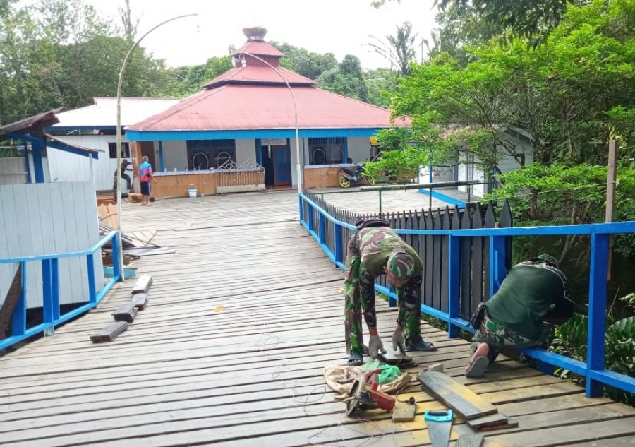 Anggota satgas TMMD saat memperbaiki pagar masjid dan melakukan pengecatan sehingga bangunan masjid tampak lebih segar dengan warna cat baru. (Foto: Kodim 0912/KBR)