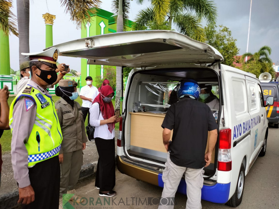 Salah satu pelanggar saat melakukan pembayaran denda kepada petugas Bapenda Paser, karena tidak mengenakan masker. (Foto : Dwi Cahyo / Korankaltim.com)