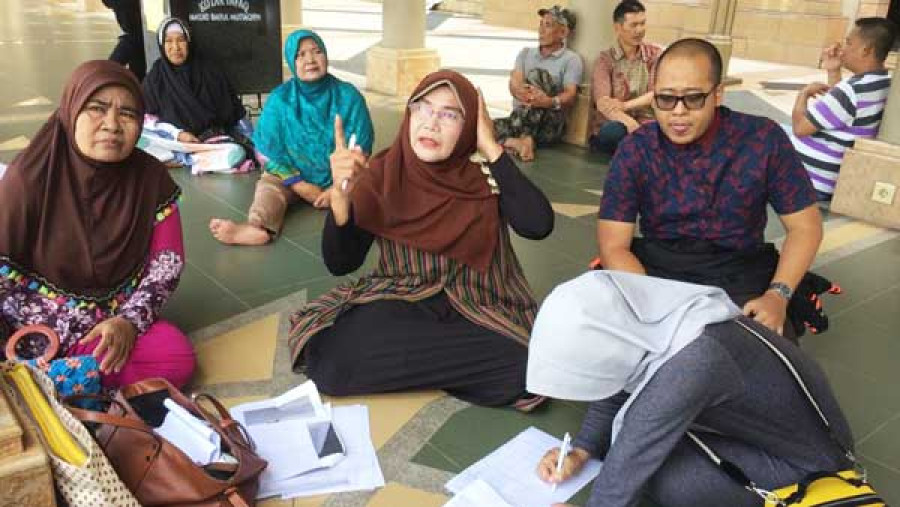 Ajeng (kacamata) saat mendata para korban calon haji yang tertipu untuk siap-siap melapor ke Polresta Samarinda.