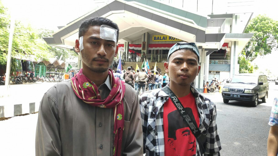 Korban dugaan pemukulan yang dilakukan oknum Satpol PP, Silvester Hengky (kiri) dan Silva Sagor (kanan) saat melakukan aksi didepan kantor Balaikota Samarinda. (Permata/KK)