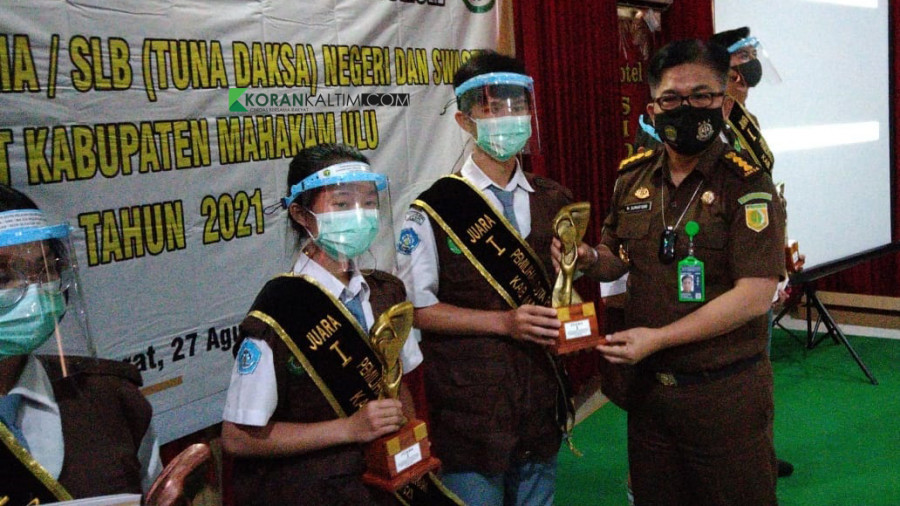 Assisten Bidang Intelejen Kejati Kaltim, M Sumartono saat menyerahkan piala kepada peringkat 1 pemilihan duta pelajar sadar hukum tingkat Kabupaten Mahulu di Aula Hotel Sidodadi, Kelurahan Simpang Raya, Kecamatan Barong Tongkok, Kamis (26/8/2021). (Foto: