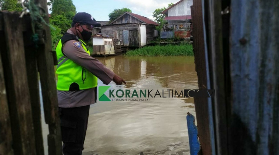 Anggota kepolisian saat menunjukkan TKP dimana korban diduga terbawa arus sungai Minggu (10/1/2021) hari ini.(Foto: Nancy/korankaltim.com)