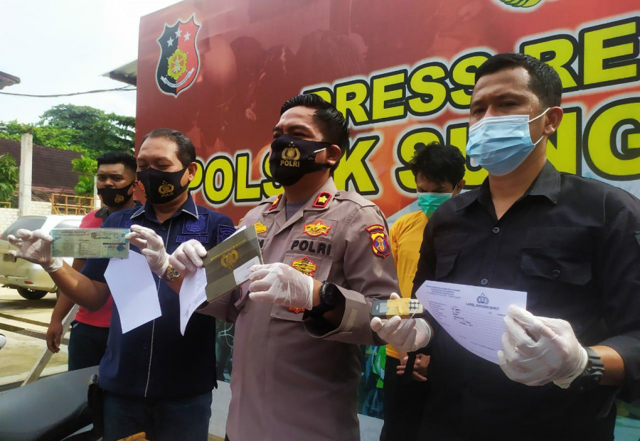 Barang bukti BPKB serta STNK motor milik korban, serta tersangka yang ditunjukkan Kapolsek Sungai Pinang, Kompol Rengga Puspo Saputro (tengah) Kamis (29/1/2021) kemarin.(Nancy/korankaltim.com)