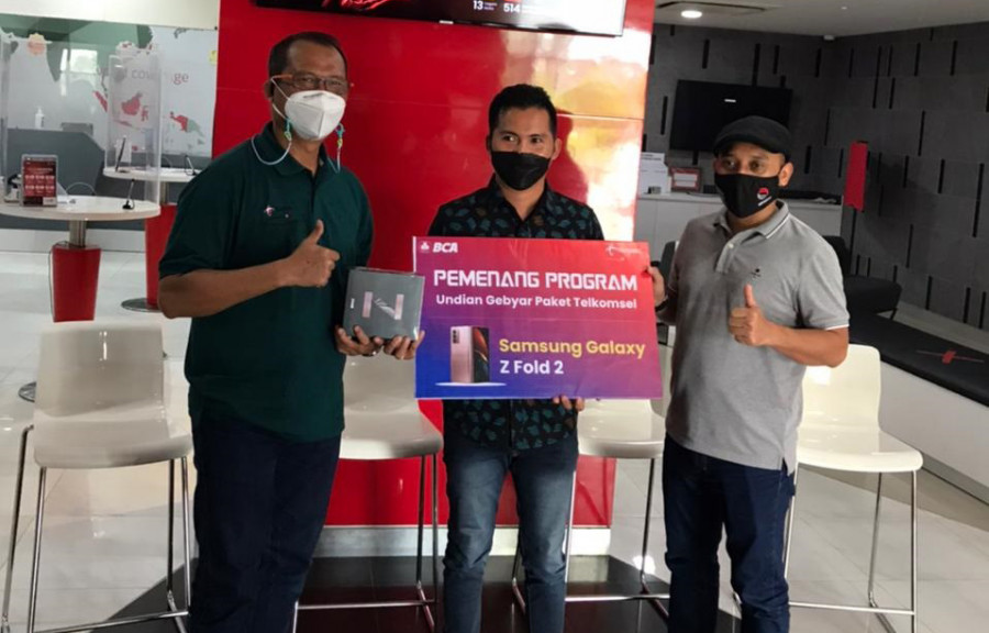 Erpendi, pelanggan Telkomsel di Samarinda saat menerima hadiah dari GM Customer Sales Regional Kalimantan Ismu Widodo didampingi Manager Branch Samarinda M Norhansyah (Dok Telkomsel)
