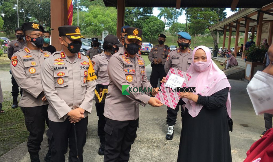 Brigjen Pol Hariyanto Wakapolda Kaltim menyerahkan bantuan uang tunai senilai Rp 1,2 juta secara simbolik kepada perwakilan pedagang kaki lima dan warung, Kamis 23 September 2021 (Foto: Iwan/Korankaltim.com)