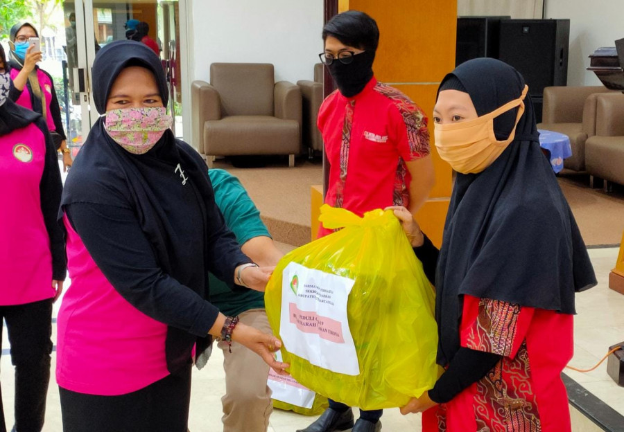 Ketua Persatuan Dharma Wanita Setkab Kukar, Yulaika Sunggono saat memberi bantuan ke salah satu petugas kebersihan setkab, Kamis (30/4/2020) (Foto: Reza Fahlevi/KoranKaltimcom)