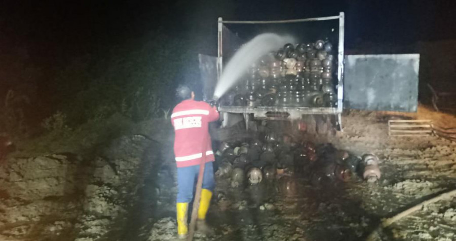 Petugas saat melakukan pembasahan pada kendaraan truk pengangkut elpiji yang terbakar (Fairus/Korankaltim.com)