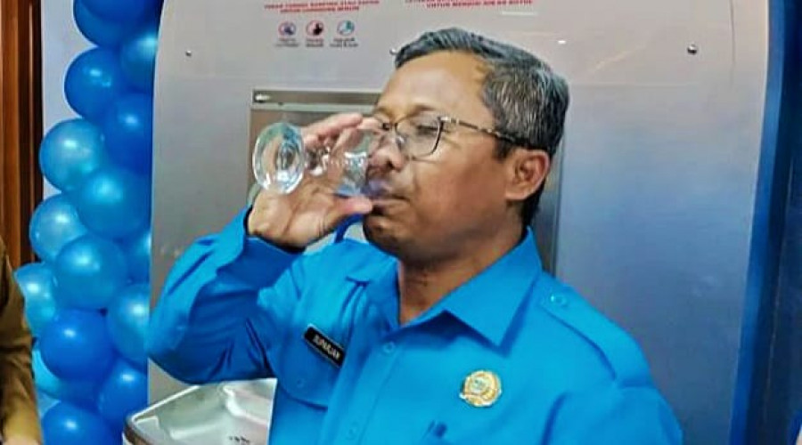 Direktur Perumda TTBKT saat minum air hasil pengolahan air baku di anjungan (Ist)