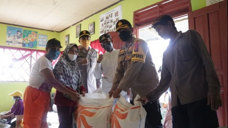 Kapolres Bontang AKBP Boyke Karel Wattimena saat memberikan bantuan beras kepada korban banjor, di Desa Makarti. (Foto:Istimewa)