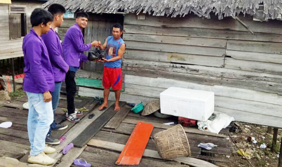 BAKTI KERJA: Mahasiswa memberikan bantuan sembako kepada warga kurang mampu di Desa Semayang ( ist )