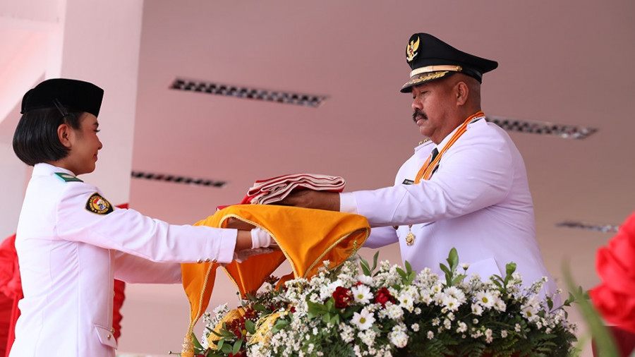 Bupati Kukar saat menyerahkan bendera pusaka kepada Gresmelia. (Foto: Prokom)