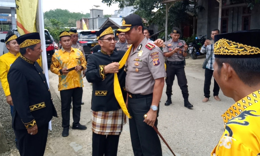 Ketua Umum LAP Arbain M Noor memasangkan Bessan Lemit ke bahu kanan Kapolres Paser AKBP Murwoto sebagai simbol persaudaraan. (Foto: Dwi Cahyo/KoranKaltim.Com)