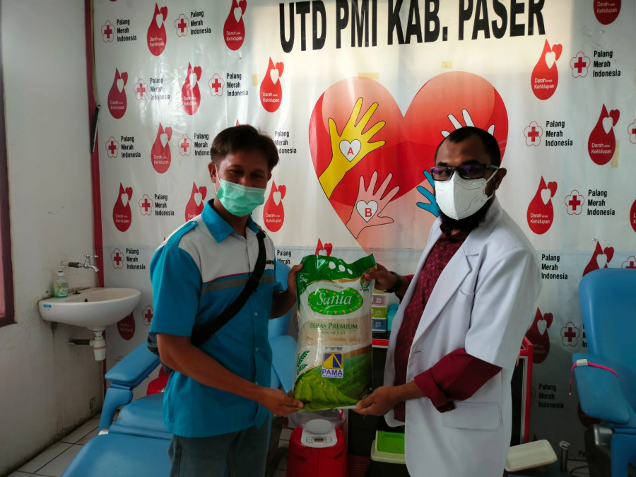 Ketua PMI Cabang Paser dr. Ahmad Hadiwijaya saat menyerahkan beras kepada salah satu Relawan Pendonor di PMI Cabang Kabupaten Paser. ( Foto: Dwi CAhyo/Korankaltim)