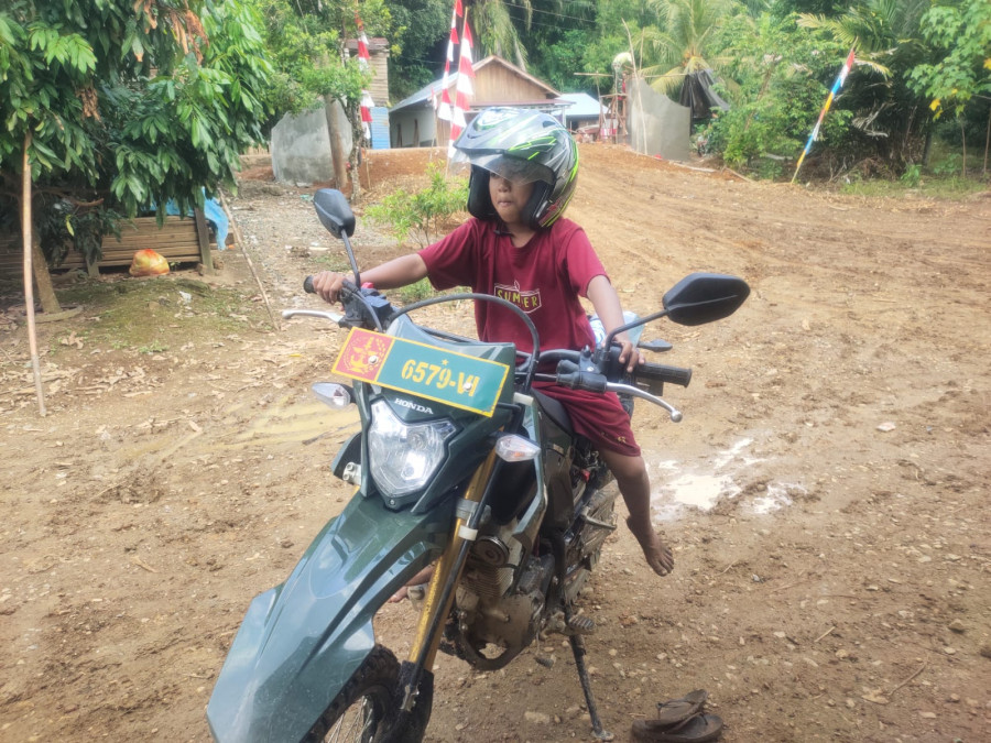 Aidil saat bergaya diatas motor dinas TNI. (Istimewa).