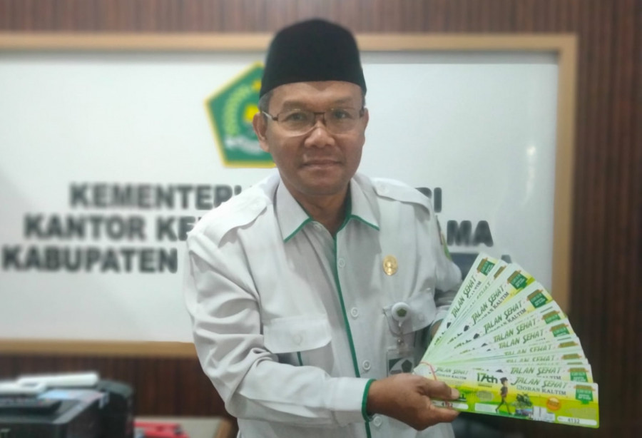 Kepala Kemenag Kukar H Nasrun menunjukkan kupon jalan sehat Koran Kaltim. Kemenag juga akan menyerahkan doorprize untuk kegiatan Jalan Sehat. (Foto: Korankaltim.com)