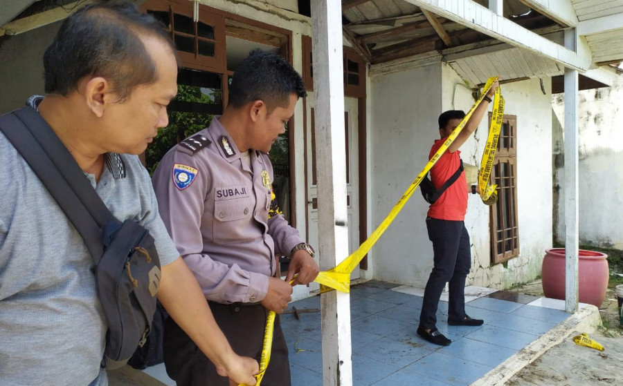 Jajaran Polsek Sungai Pinang saat melakukan pemasangan police line di rumah korban, yang ditemukan tak bernyawa di dalam rumahnya. (Foto: Nancy/korankaltim.com)