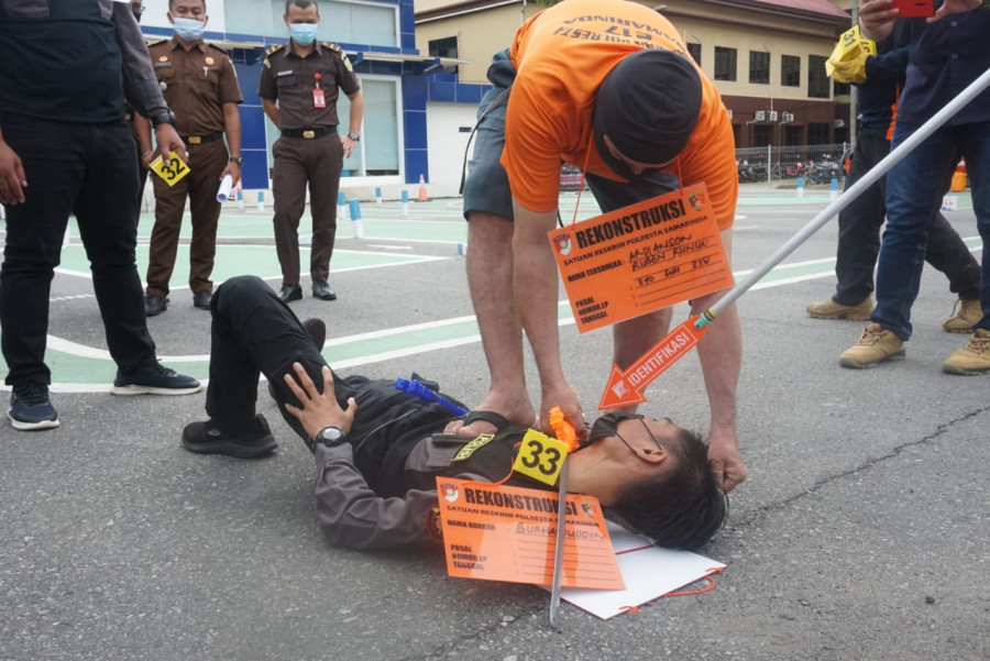Adegan saat AN (52) menghabisi nyawa Burhanudin (52) dengan sebilah parang Selasa (4/5/2021) di halaman belakang Mako Polresta Samarinda. (Foto:Nancy/korankaltim.com)
