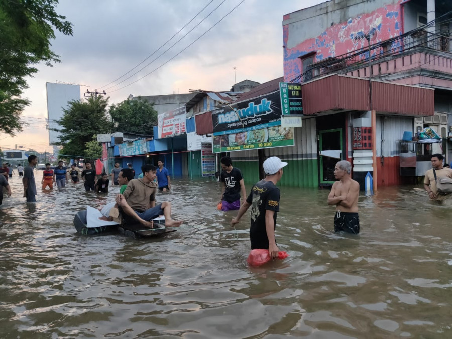 Masyarakat Jalan Dr Sutomo Asyik Memanfaatkan Jalan Raya Yang Terendam Banjir Sebagai Lahan Bermain