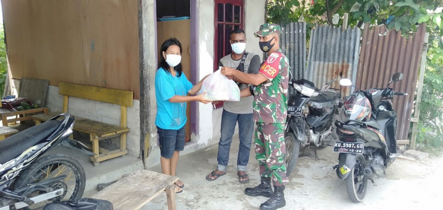 Babinsa dari Kodim 0907/Trk saat memberikan bantuan sembako kepada warga binaan yang kurang mampu. (Foto: Pendim 0907/Trk)