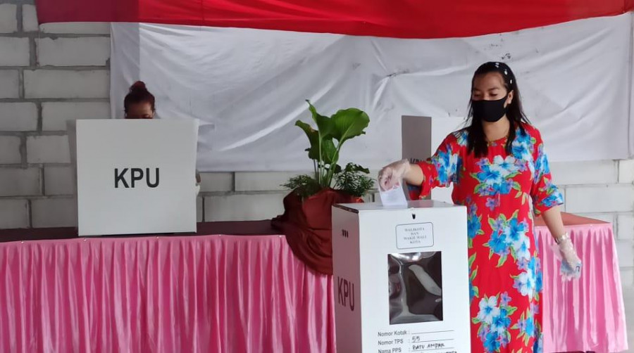 Seorang perempuan memasukan surat suara ke dalam kotak usai menentukan pilihan dalam bilik TPS 055 Kelurahan Batu Ampar, Balikpapan Utara. (Foto: Hendra/KoranKaltim.Com)