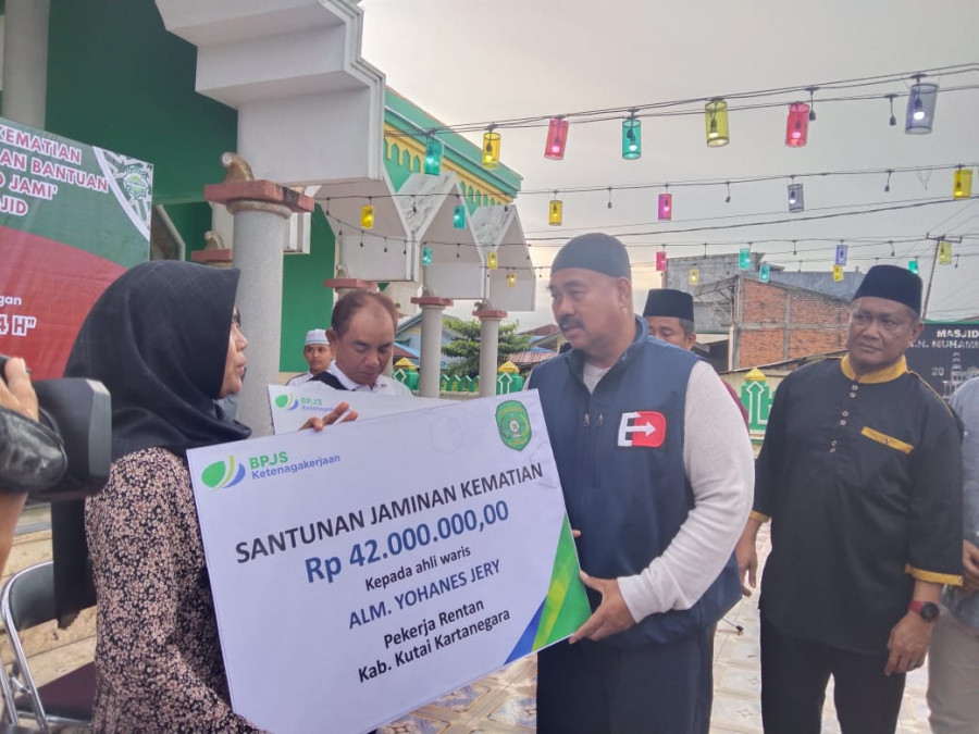 Bupati Kukar, Edi Damansyah saat menyerahkan secara simbolis santunan jaminan kematian bagi pekerja rentan yang diterima oleh ahli waris dan bantuan sembako bagi keluarga pra sejahtera. (handayan/korankaltim.com)