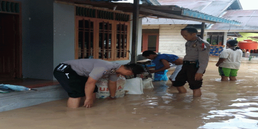 Sejumlah personel kepolisian mengevakuasi barang-barang mereka yang terendam banjir.