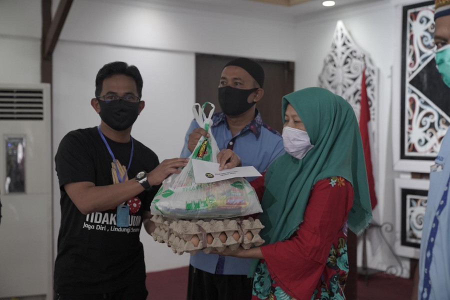 Pembina RMC, Rahmad Mas'ud (kiri) memberikan bantuan berupa sembako dan uang tunai. (Foto: Istimewa/KoranKaltim.Com)