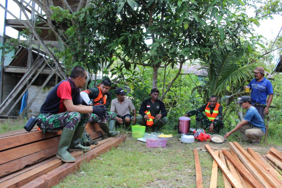 Disela istirahat kerja, anggota satgas bersama masyarakat menikmati kopi dan camilan yang di siapkan oleh warga sekitar lokasi TMMD. (Kodim 0912/KBR)