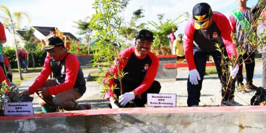 POHON DEMOKRASI : Pj Sekda Kota Bontang Artahnan menyiram tanaman pohon demokrasi yang ditanam di Taman Adipura kemarin. foto dokumen humas/adie.