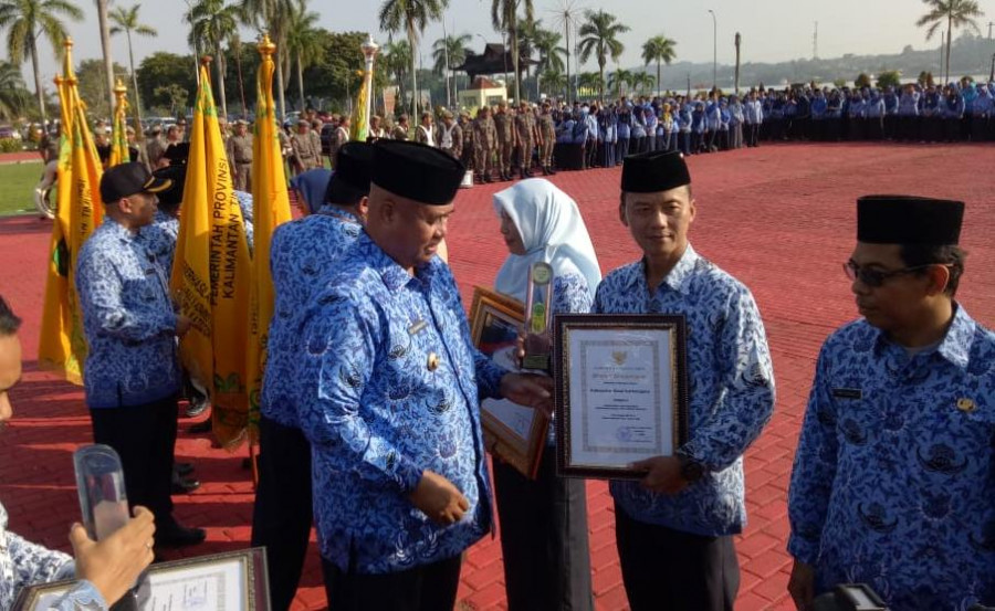 Bupati Kukar Edi Damansyah saat memberikan Panji keberhasilan dan piagam penghargaan kepada 7 kepala OPD, Jumat (17/1/2020). ( Foto: Reza/korankaltimcom)