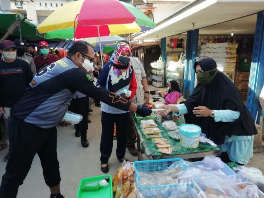 Plt Bupati Kutim, Kasmidi Bulang bersama Tim Gugus Tugas imbau masyarakat terapkan protokol kesehatan sekaligus membagikan masker (Zulhamri/korankaltim.com)