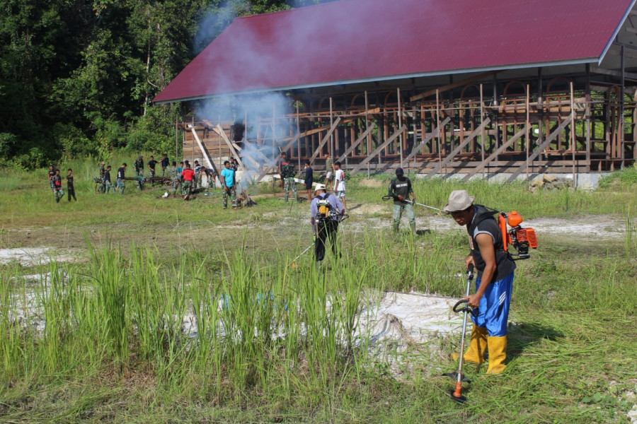 Anggota satgas TMMD dan masyarakat setempat mulai membersihkan dan mempersiapkan lokasi yang akan digunakan dalam acara penutupan kegiatan TMMD pada 9 Juni mendatang. (Foto: Kodim 0912/KBR)
